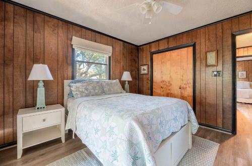 a bedroom with wooden walls and a bed and a window at The Green House in Kitty Hawk