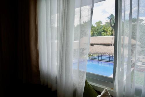 a window with a view of a swimming pool at Kaway Resort & Spa in Tabuelan