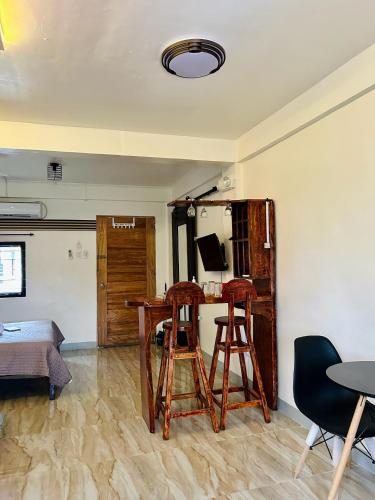 a room with two stools and a desk with a computer at Espazzi Apartment in Tacloban