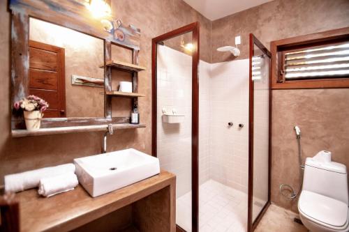 a bathroom with a sink and a shower and a toilet at Paraíso Casa Branca in Arraial d'Ajuda