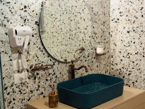 Wujoud - 5 Bedroom Apartment في القاهرة: حمام مع حوض أزرق ومرآة