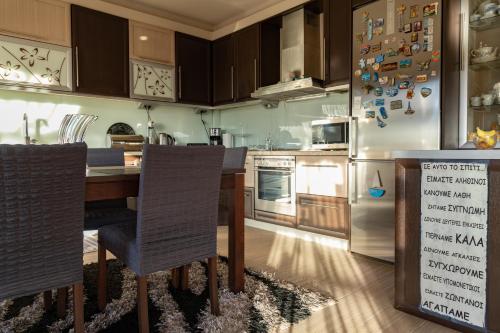 una cocina con una mesa y un refrigerador en The Sunset Haven Kastoria - Modern Lake Elegance, en Kastoria