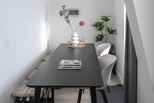 einen schwarzen Esstisch mit einer Vase darauf in der Unterkunft 6p newly renovated home with unique roof-terrace in Strijp