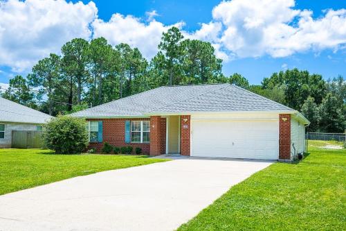 a red brick house with a white garage at The Breeze in Navarre