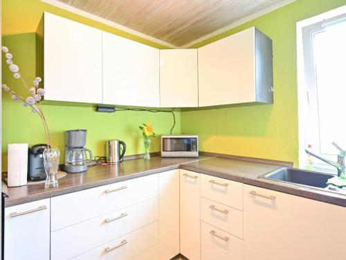 a kitchen with white cabinets and a sink at Bärenhöhle in Marktleuthen
