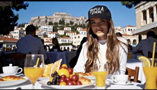 a woman sitting at a table with a plate of food at Triple A - Athena Collection - Heart of Athens - Near Famous Mokka Coffee- FREE Parking! in Athens