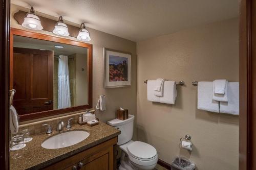 ein Badezimmer mit Waschbecken, Toilette und Spiegel in der Unterkunft Everline Resort & Spa #718 & #720 in Olympic Valley