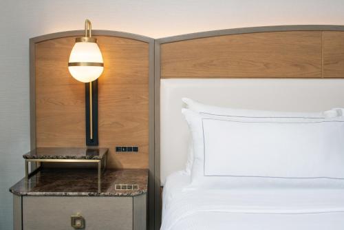 a bedroom with a bed and a lamp on a night stand at Hilton Milwaukee in Milwaukee