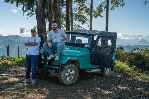 a man and a woman sitting on a green jeep at Finca La Manchuria in Salgar