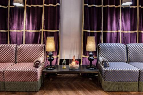 two chairs and a table in a room with purple curtains at Aqua Palace in Venice
