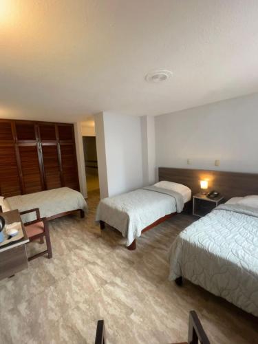 a hotel room with two beds and a table at Eurohotel in Panama City