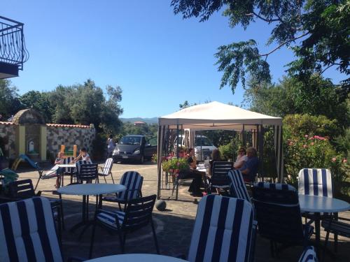a patio with tables and chairs and a white umbrella at Villa Malandrino Guest House in Agropoli