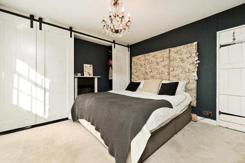 a bedroom with a large bed and a chandelier at South Downs home in Ditchling