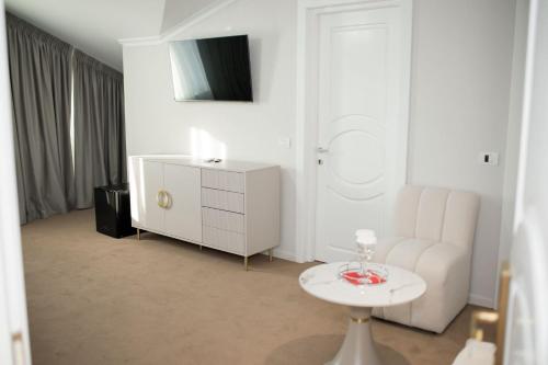 a white living room with a white couch and a table at Pensiunea Paradis in Râmnicu Vâlcea