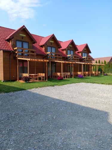 Una gran cabaña de troncos con techo rojo en Ozi-Holiday, en Rusinowo