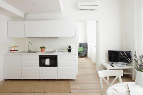 a white kitchen with a sink and a microwave at The Riverside Suite in Mira