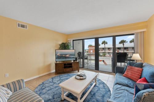 a living room with a couch and a tv at Sandcastles 413 in Cocoa Beach
