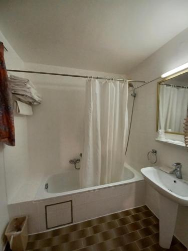 a white bathroom with a tub and a sink at Koffieboontje Budget in Bruges
