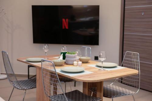 a dining room table with chairs and a tv at Evis Cosmos 1 - Meno Homes 10 in Xanthi