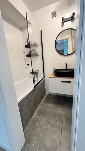 a bathroom with a sink and a mirror at Apartment by Psie Pole in Wrocław