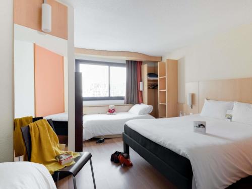 a hotel room with two beds and a window at ibis Paris 17 Clichy-Batignolles in Paris