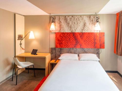 a bedroom with a bed and a desk with a laptop at ibis Paris 17 Clichy-Batignolles in Paris