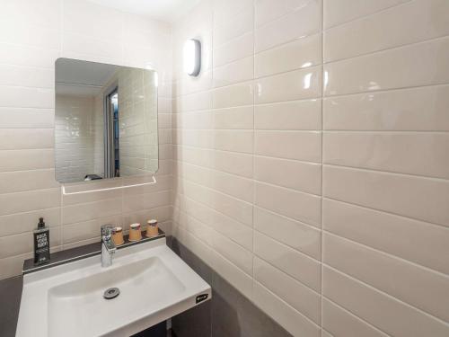 a white bathroom with a sink and a mirror at ibis Paris 17 Clichy-Batignolles in Paris