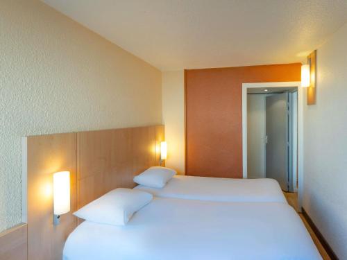 a bedroom with a large white bed with two pillows at ibis Paris 17 Clichy-Batignolles in Paris