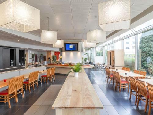 a restaurant with tables and chairs and a counter at ibis Paris 17 Clichy-Batignolles in Paris