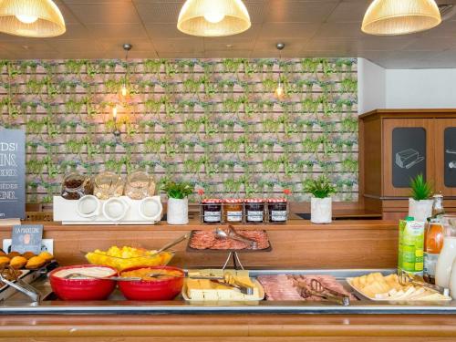 a buffet with meat and other food on a counter at ibis Paris 17 Clichy-Batignolles in Paris