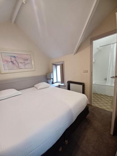 a bedroom with a large white bed and a window at Koffieboontje Budget in Bruges