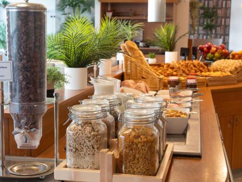 a counter with several jars of nuts on a table at ibis Paris 17 Clichy-Batignolles in Paris