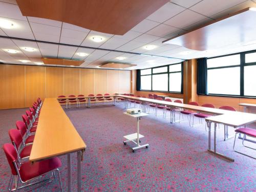 a conference room with tables and red chairs at ibis Paris 17 Clichy-Batignolles in Paris