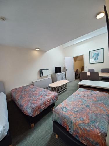 a hotel room with two beds and a living room at Koffieboontje Budget in Bruges