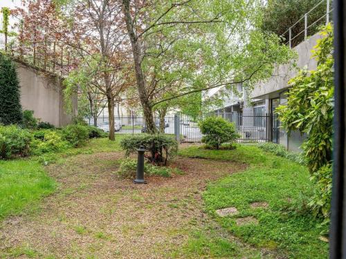 a garden with a tree and a bench in a yard at ibis Paris 17 Clichy-Batignolles in Paris