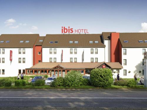 a hotel with a sign that reads ibis hotel at ibis Charleroi Airport Brussels South in Charleroi