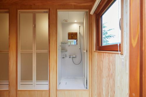 a bathroom with a shower with a glass door at Yonezawa Misawa Elementary School - Vacation STAY 06437v in Yonezawa