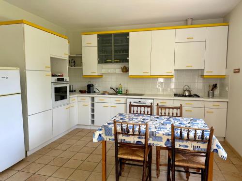 a kitchen with white cabinets and a table with chairs at Château Chevreuil in Fresnay-en-Retz