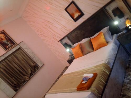 a bedroom with a large bed with orange pillows at De-Manna Ota in Otta