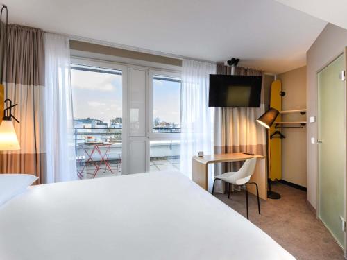 a hotel room with a large bed and a balcony at ibis Luebeck City in Lübeck