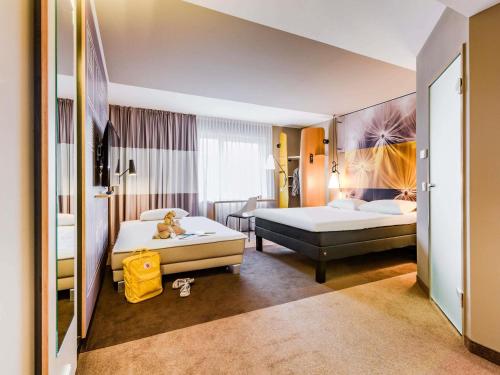 a hotel room with two beds and a couch at ibis Luebeck City in Lübeck