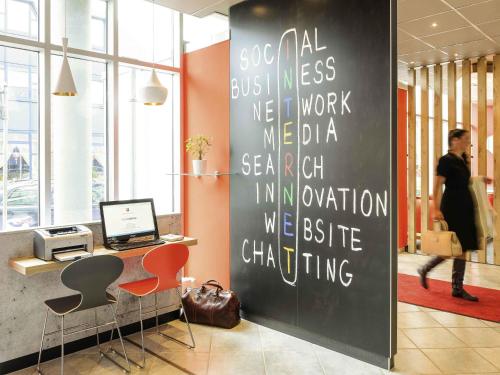 an office with a black wall with writing on it at ibis Luebeck City in Lübeck