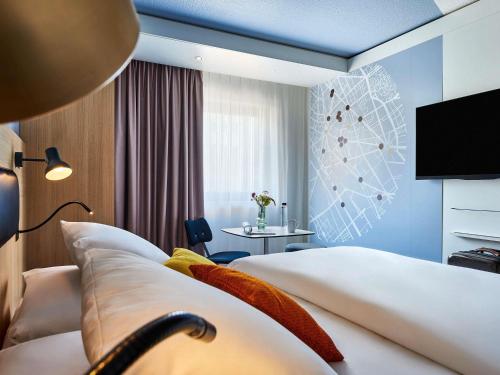 a hotel room with two beds and a television at Mercure Paris Gare De Lyon TGV in Paris