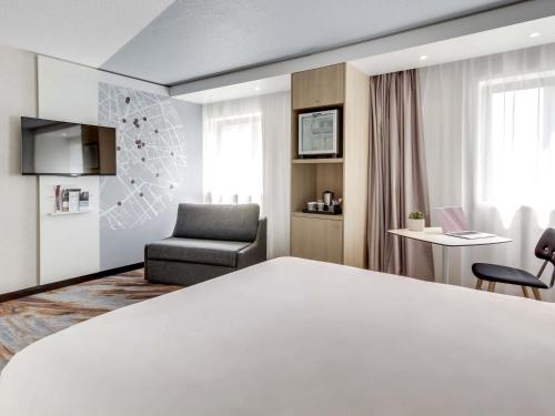a hotel room with a bed and a chair at Mercure Paris Gare De Lyon TGV in Paris