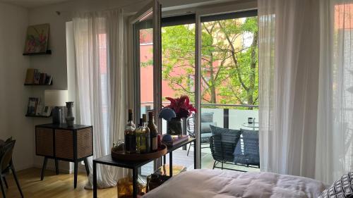 a bedroom with a bed and a table with wine bottles at Modern & Cozy Apartment Münchner Freiheit with Balcony in Munich