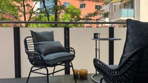 two chairs and a table on a balcony at Modern & Cozy Apartment Münchner Freiheit with Balcony in Munich