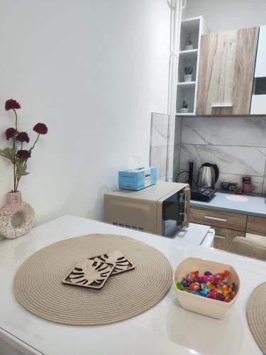 a kitchen counter with a microwave and a bowl of candy at Sweet home in Bor