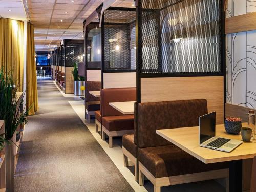 a restaurant with a laptop sitting on a table at Mercure Paris Gare De Lyon TGV in Paris