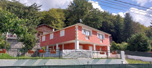 a red house with a fence in front of it at Casa Sofia La Dimora delle Fate in Bagnoli Irpino