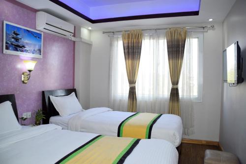 カトマンズにあるpeaceful green Room at Thamelのベッドが2つと窓があるホテルの部屋